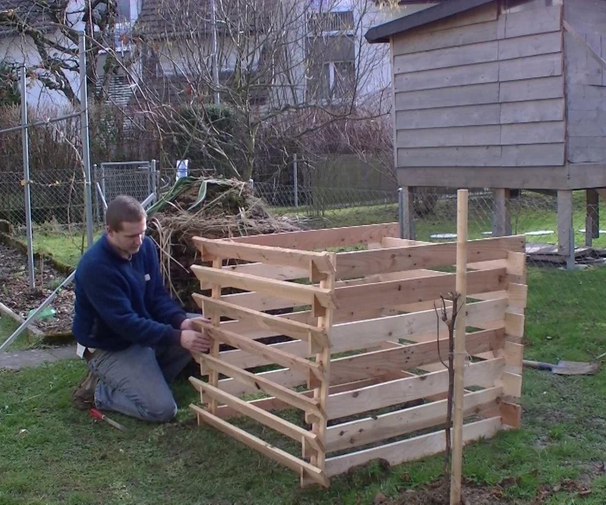 Wooden compost bin in backyard garden