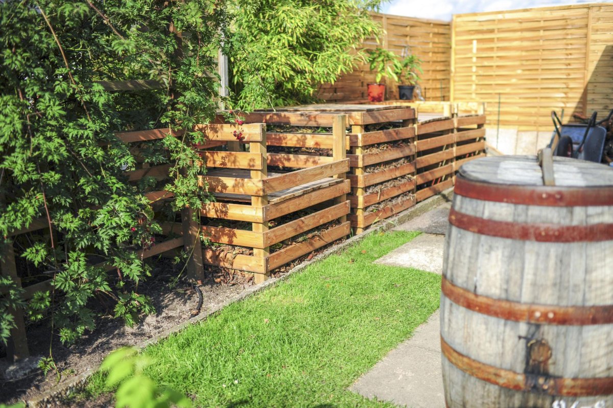 Compost bin beside garden fence