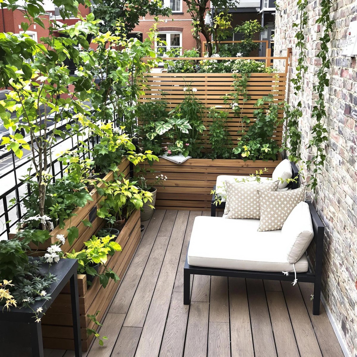 Narrow balcony garden with wooden raised planters, slatted privacy screen, and white outdoor sofa
