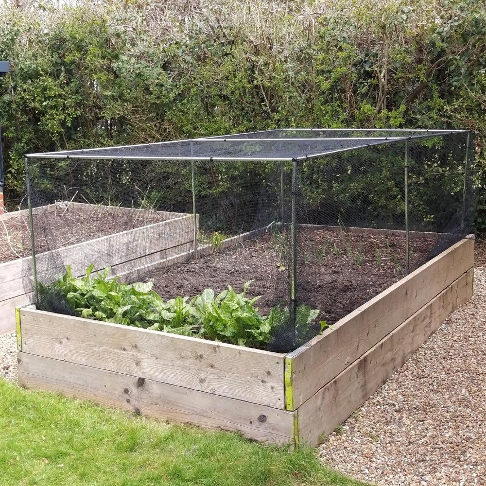 Mesh barrier around raised garden bed